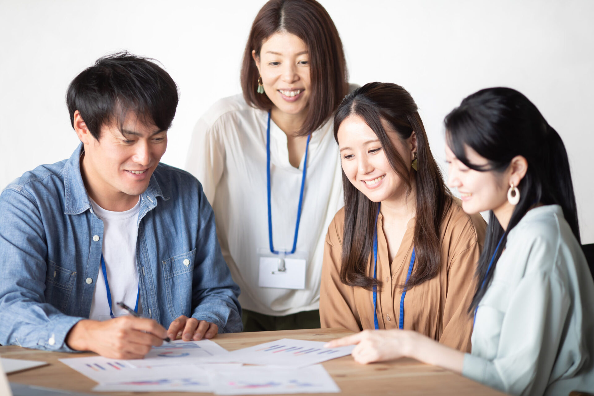 男女4名が資料を見ながら会話する様子